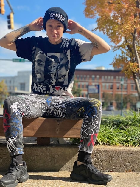 A man wearing relaxed-fit cargo pants with multiple pockets, paired with high-top sneakers and a graphic t-shirt in an urban setting.