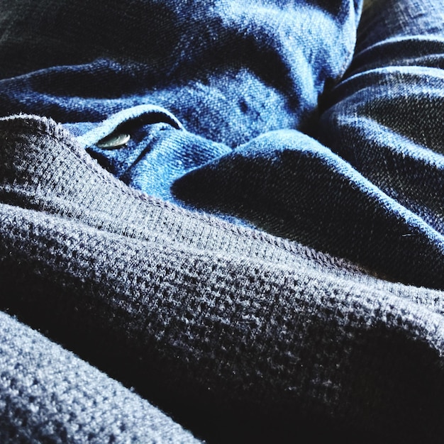 A detailed shot of different fabric textures used in streetwear, focusing on cotton, denim, and a modern technical fabric. Each fabric should be labeled with its name and key properties (e.g., 