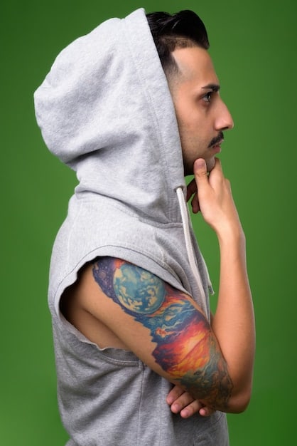 A young man wearing a customized hoodie with unique patches and embroidery, showcasing the personalized and artistic elements of DIY streetwear.