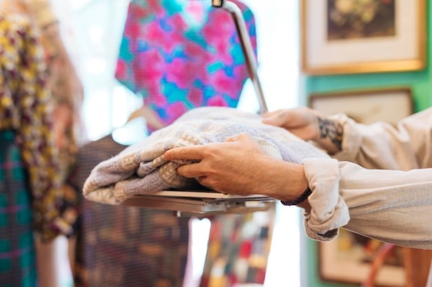 A close-up shot of a person's hands sorting through a rack of vintage clothing in a thrift store. The focus is on the textures and patterns of the garments, with tags and labels visible. The store has a cluttered, authentic feel, emphasizing the hunt for hidden gems.