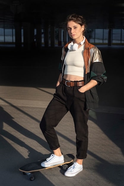 A full-body shot of a woman confidently wearing baggy jeans paired with a fitted black top, stylish sneakers, and a vibrant crossbody bag, illustrating the balance between oversized and fitted pieces.