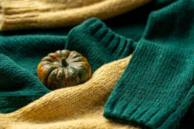 A close-up shot of a stack of folded sweaters in autumnal colors like burgundy, navy, and forest green. The sweaters are neatly arranged to showcase the different textures and knits.