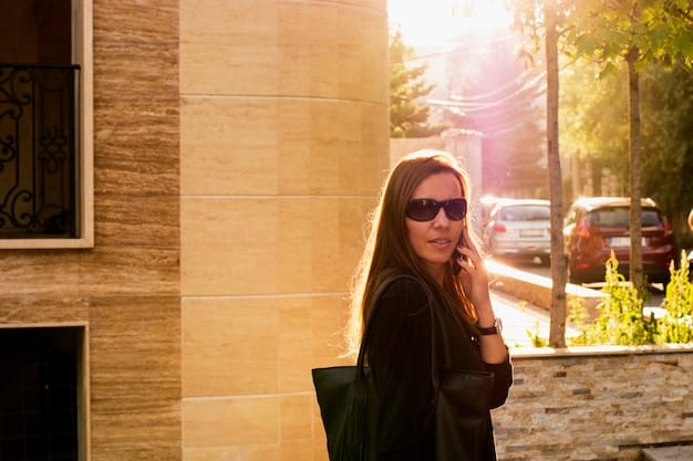 A person wearing stylish sunglasses with mirrored lenses while walking in a sunny urban environment.