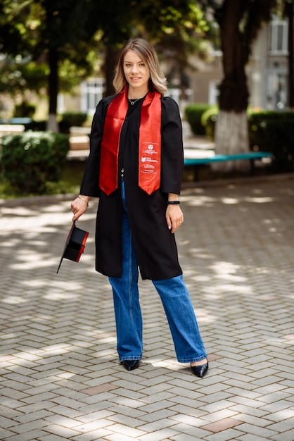 A woman wearing a black blazer over a white t-shirt and jeans, accessorized with simple jewelry and ankle boots. The setting is a modern, urban café. The photo highlights how a blazer can elevate a casual outfit for a stylish, everyday look.