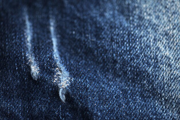 A close-up shot of different denim washes, showcasing the varying shades of blue and levels of distressing, including light wash, dark wash, raw denim, and acid wash.