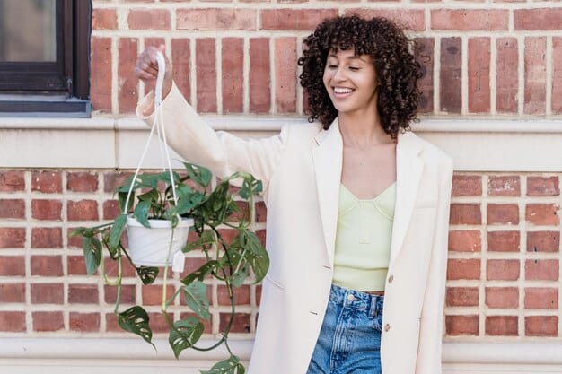 A person in their 40s is wearing a stylish, sustainable urban outfit, including a recycled denim jacket and organic cotton trousers. They are standing in front of a mural, showcasing eco-friendly fashion.