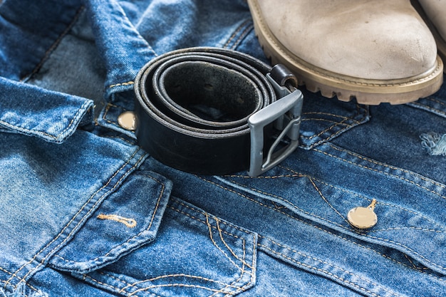 A close-up shot of a variety of different jean cuffs, from thick single cuffs to pin-rolled cuffs, showcasing the different textures and washes of the denim. The background is a blurred urban setting.