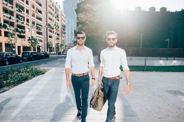 Two people walking side-by-side in a city, one with expertly cuffed shirt sleeves revealing a stylish watch, and the other with a jacket cuff folded back to expose a contrasting inner lining.