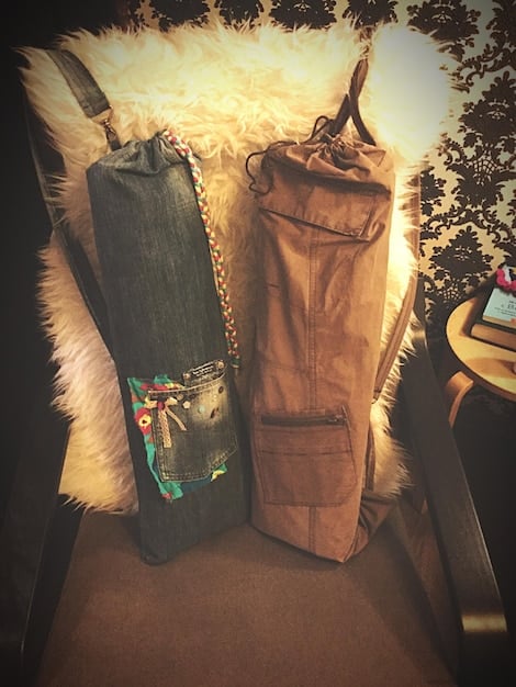 A curated rack of vintage clothing in a boutique setting, featuring a variety of textures such as leather jackets, silk scarves, and denim jeans with modern accessories like belts and bags.