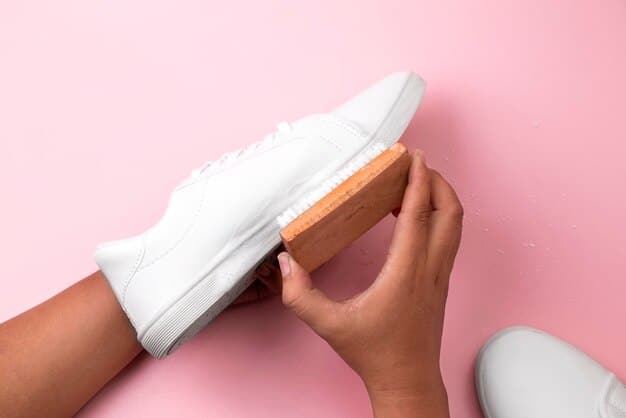 A close-up shot of a person's hands carefully cleaning a pair of white leather sneakers with a soft brush, highlighting the importance of maintenance in preserving the value of a sneaker collection.