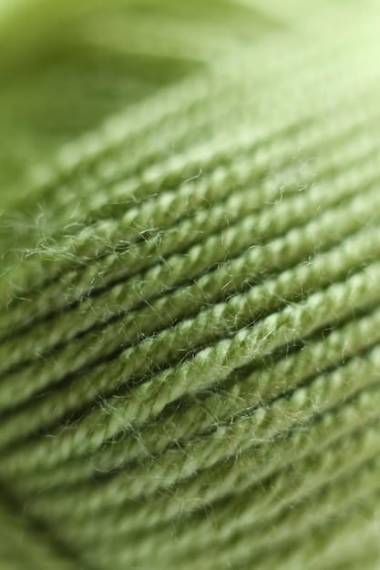 A close-up shot of fabric samples showcasing different sustainable textures: one appears to be subtly patterned recycled polyester, another is a soft, natural hue of organic cotton, and a third shows the subtle sheen of bamboo fabric, laid out on a wooden surface.
