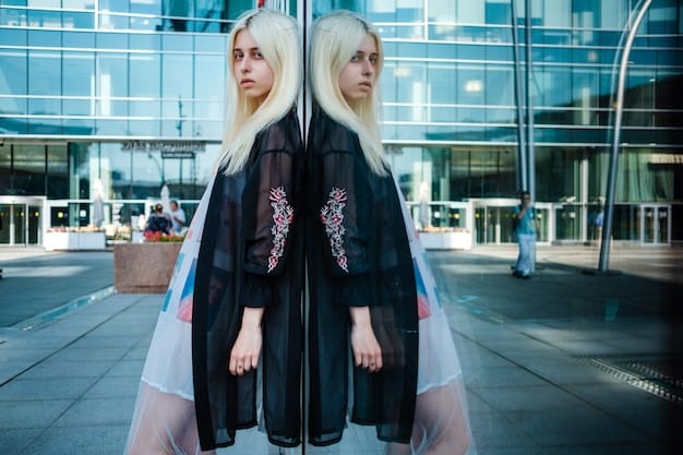 A woman with vibrant hair, wearing a sleek black jumpsuit, showcasing a collection of layered silver and gold necklaces with geometric pendants, and multiple stacking rings on her fingers. The background features blurred neon lights of a city.