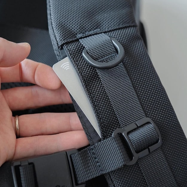 A detailed shot of a water-resistant backpack with a roll-top closure, featuring reinforced seams and subtle reflective accents. The texture of the fabric is visible, highlighting its technical nature.