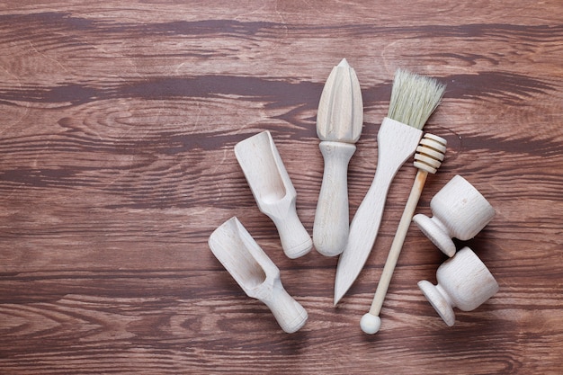 A pair of white sneakers on a workbench, with various cleaning supplies like a brush, soap, and deglazing solution laid out neatly beside them, indicating preparation.