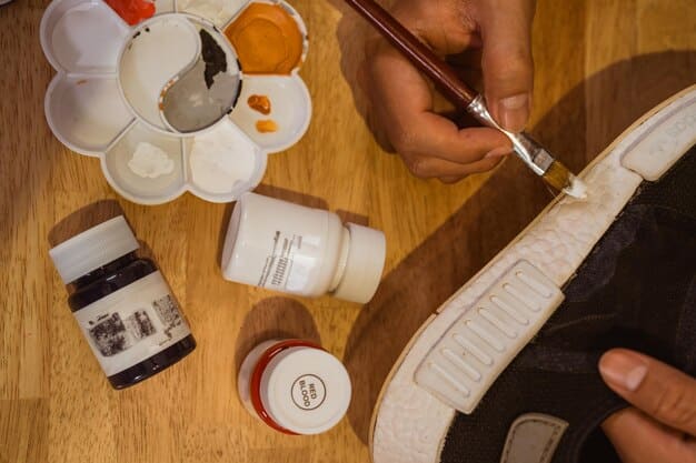 A close-up of an artist's hands meticulously working on a sneaker with a fine-tipped brush, adding intricate detail to a custom design. The focus is on the precision and concentration involved in the artistic process.