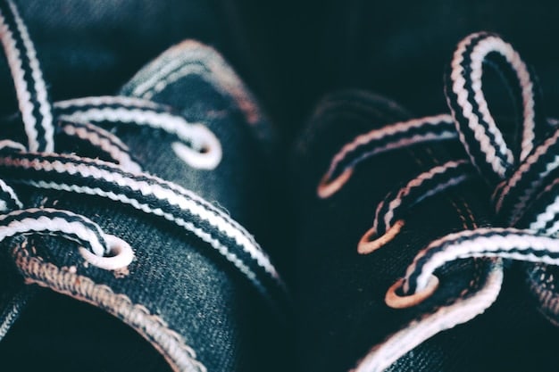 A detailed comparison shot of a sneaker's stitching patterns, with one side showing perfectly aligned, tight stitches (authentic) and the other showing slightly uneven, loose stitching (fake).