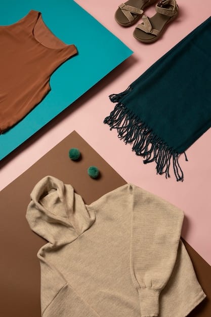 A flat lay of various layered clothing items showcasing a harmonious color palette with contrasting textures, e.g., a ribbed knit sweater, a silk camisole, a denim jacket, and wool trousers.